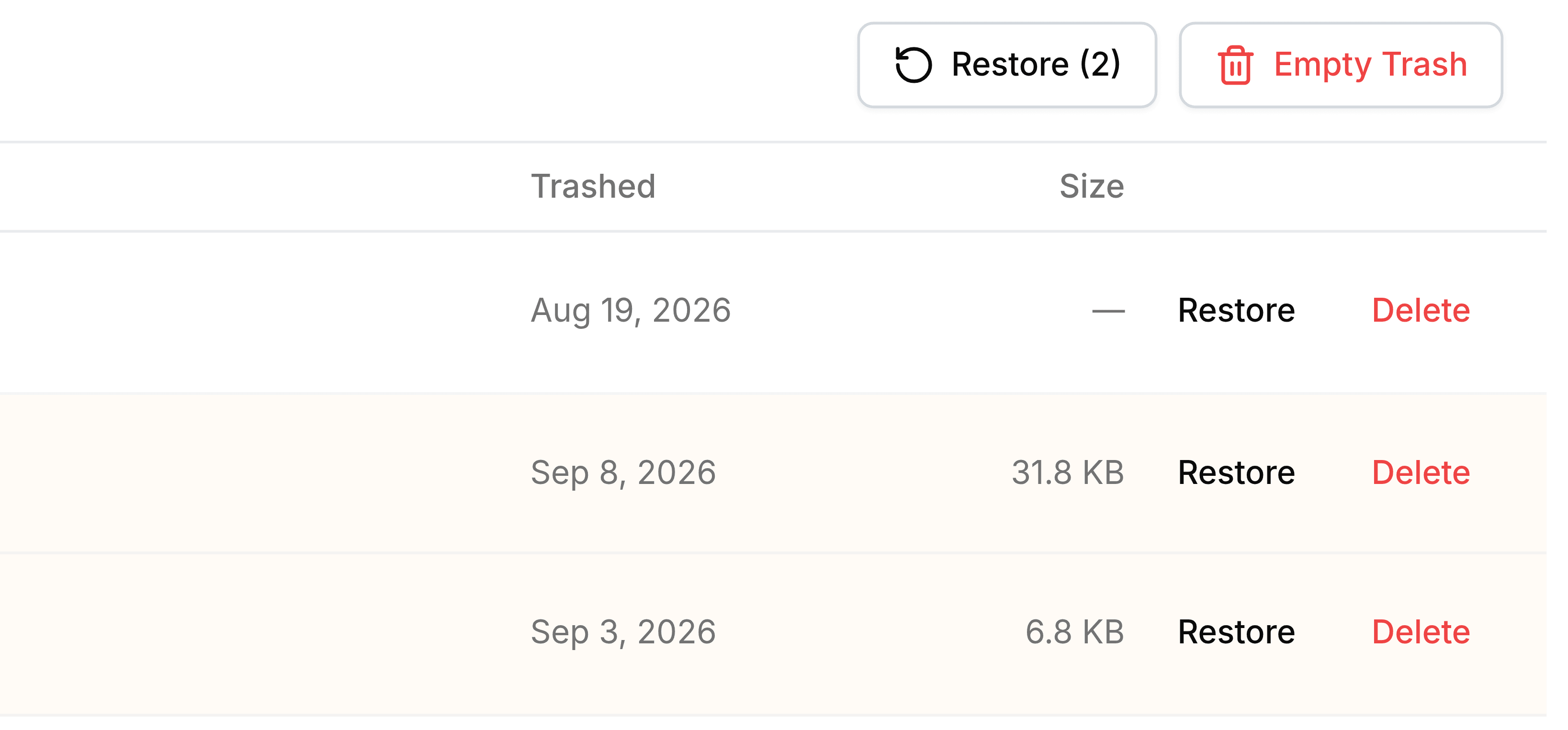 The top right of Trash with two rows ticked: a Restore (2) button has appeared beside the red Empty Trash button, and the two ticked rows below are tinted pale orange.