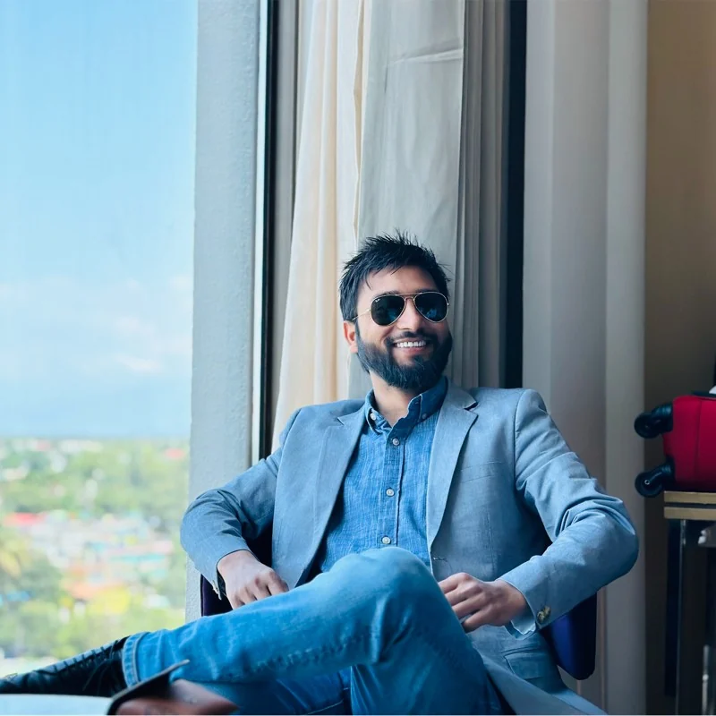 Deepak Gupta seated by a window, smiling
